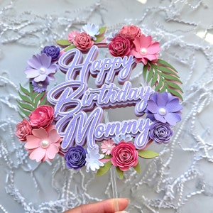 Op de afbeelding: Paarse en roze papieren bloemen caketopper met de tekst "Happy Birthday Mommy".