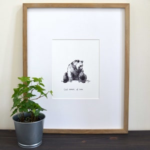 May include: A framed black and white ink drawing of a bear sitting down. The drawing is titled "Coolest moments are silent".