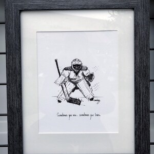 May include: Black and white line drawing of a hockey goalie in a framed print. The print has the text "Sometimes you win. Sometimes you learn."