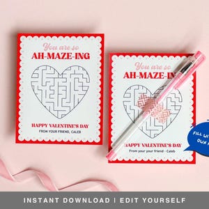 May include: Two red and white Valentine's Day cards with a heart-shaped maze on each. The text on the cards reads "You are so AH-MAZE-ING" and "HAPPY VALENTINE'S DAY". One card has a pink pen on top of it and the text "FILL WITH YOUR OWN NAME!" in a blue speech bubble.