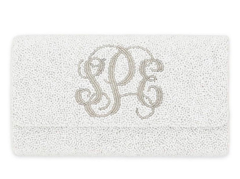 May include: White beaded clutch with a silver monogram of the letters "SPE".