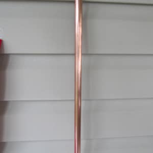 May include: A long, straight copper pipe.