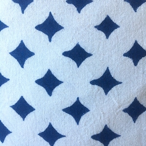 May include: White fabric with a repeating pattern of dark blue diamond shapes.