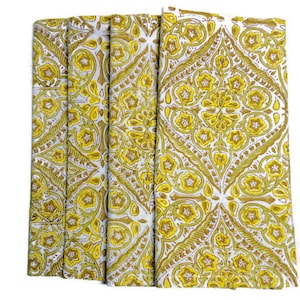 May include: Set of four white cotton napkins with a yellow and brown floral pattern.