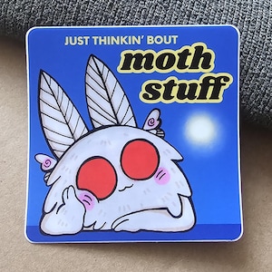 May include: Square sticker with a cartoon moth character. The moth has large red eyes, a white body, and feathery antennae. Text on the sticker reads "JUST THINKIN' BOUT moth stuff" in yellow and white.