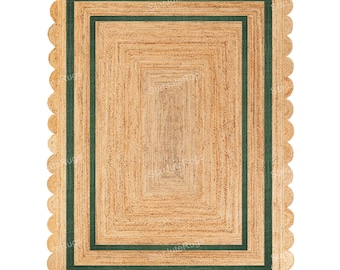 May include: Rectangular jute rug with a scalloped edge. The rug features a central rectangular design with a dark green border. The natural tan color of the jute contrasts with the green border, creating a visually appealing design.