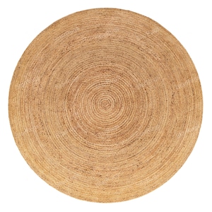 May include: A round jute rug with a natural, light brown color. The rug has a concentric circular pattern, creating a textured surface. This rug is suitable for various home decor styles.