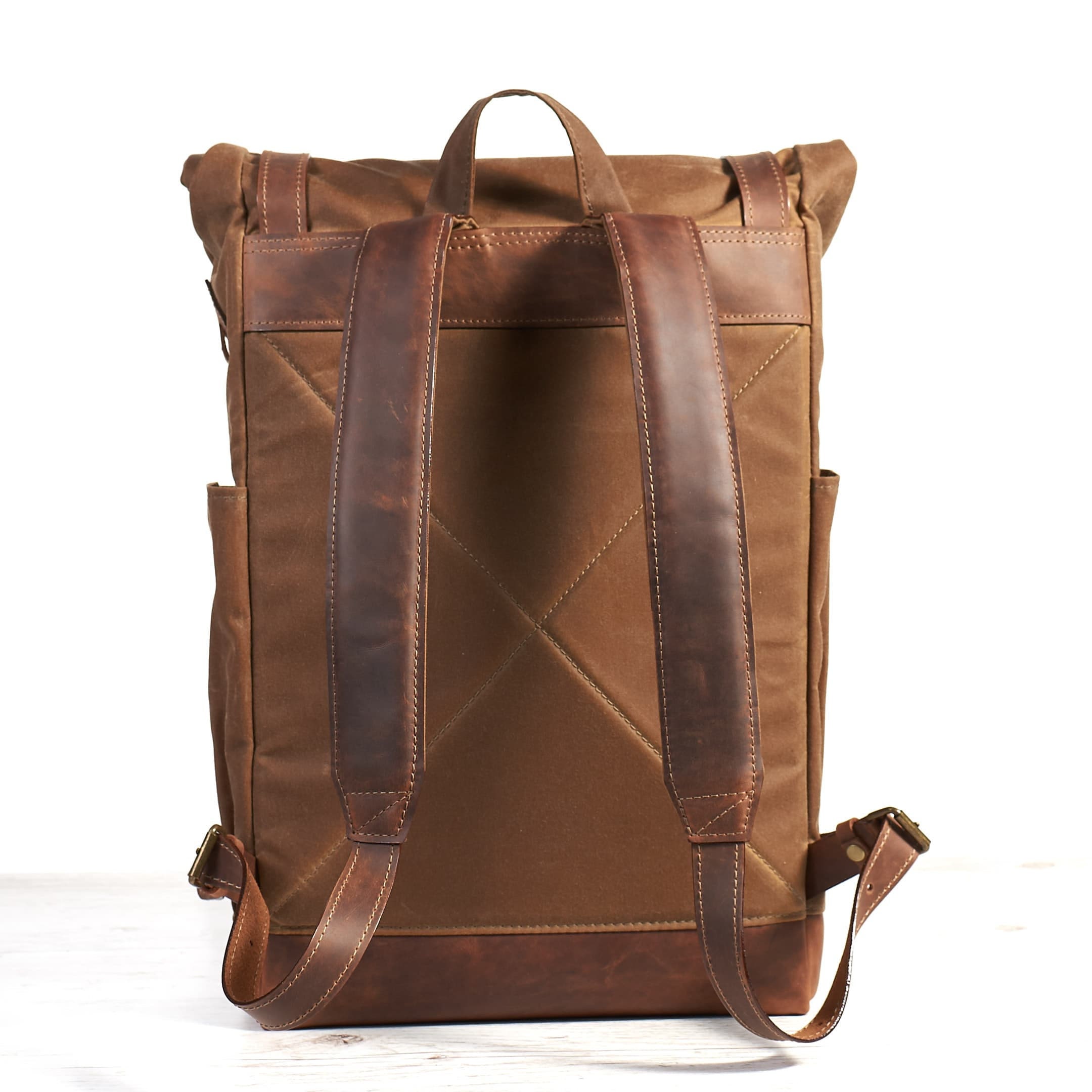 Tan brown waxed canvas backpack with molle grid. Leather crossbody bag.