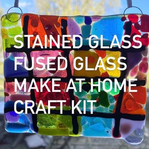 May include: A stained glass and fused glass craft kit with colorful glass pieces and black lines. The kit includes everything you need to make a beautiful stained glass project at home. The text on the kit reads "Stained Glass Fused Glass Make at Home Craft Kit".