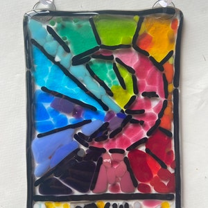 May include: A colorful stained glass art piece with a rainbow design and the number "XVIII" at the bottom.