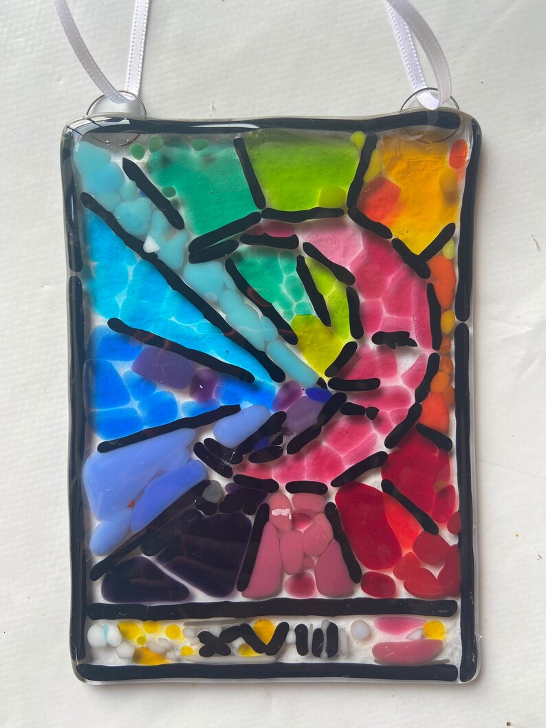 May include: A colorful stained glass art piece with a rainbow design and the number "XVIII" at the bottom.