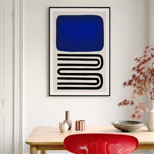 May include: A framed wall art print featuring a large solid blue rectangle positioned above a series of black horizontal lines that form a continuous, repeating U-shaped pattern against a light beige background within a thin black frame.