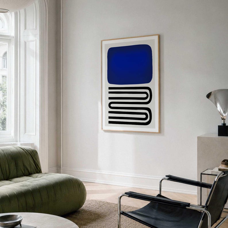 May include: A framed vertical wall art print featuring a solid dark blue rounded rectangle positioned above a series of stacked black horizontal U-shaped lines on a light gray background, displayed in a light-colored wooden frame.