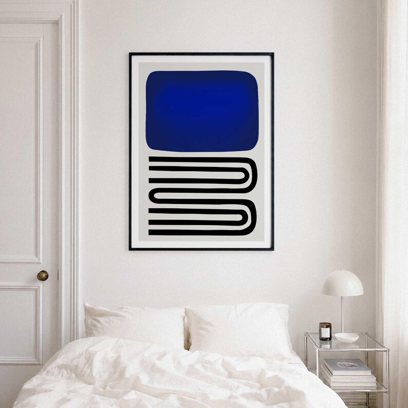 May include: A framed wall art print featuring a large solid blue rectangle positioned above a series of black horizontal lines that form a repeating, interconnected U-shaped pattern on a light gray background within a thin black frame.