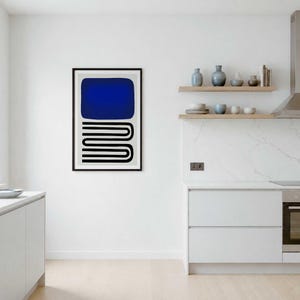May include: A framed wall art print featuring a large solid blue rectangle positioned above a series of black horizontal lines that form a repeating, interconnected U-shaped pattern on a light gray background, displayed in a kitchen setting.