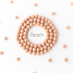 May include: A circle of peach-coloured makeup balls with the word "Peach" in the centre.