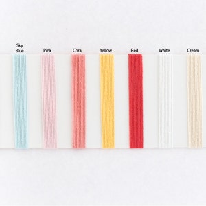 May include: A color chart showing different string colors: black, sky blue, pink, coral, yellow, red, white, and cream. The text "String Colour" is printed on the chart.