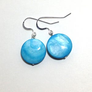 May include: A pair of silver dangle earrings with round blue and white shell-like stones.