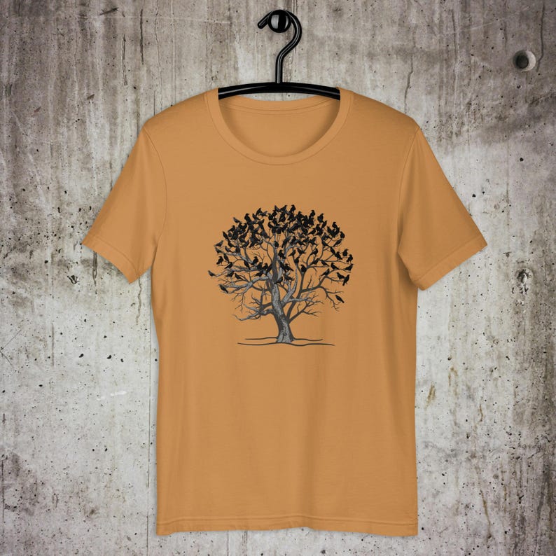 May include: A mustard yellow t-shirt with a black and white graphic of a tree with birds on the branches.