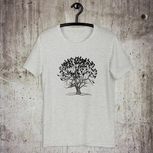 May include: A heather gray t-shirt with a black and white graphic of a tree with birds on the branches.