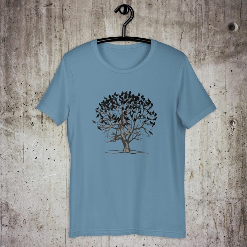 May include: A light blue t-shirt with a graphic of a tree with many black birds perched on its branches.
