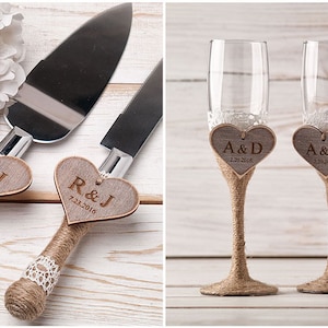 May include: Two sets of wedding cake cutting knives and champagne flutes with personalised wooden heart tags. The tags are decorated with burlap and lace. The cake knife set has the initials "R&J" and the date "7.23.2016". The champagne flutes have the initials "A&D" and the date "2.20.2016".