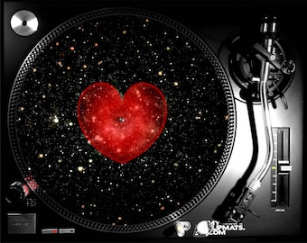 May include: A black turntable with a red heart-shaped design on the platter. The heart is filled with a galaxy-like pattern of stars and swirls. The turntable is a popular item for DJs and music lovers.