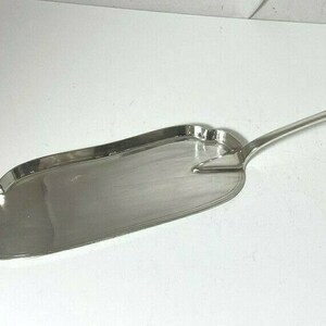 以下が含まれることがあります： 長い柄と幅広で平らなボウルを持つ銀製のサービングスプーン。ボウルは波状の縁とわずかに湾曲した形をしています。