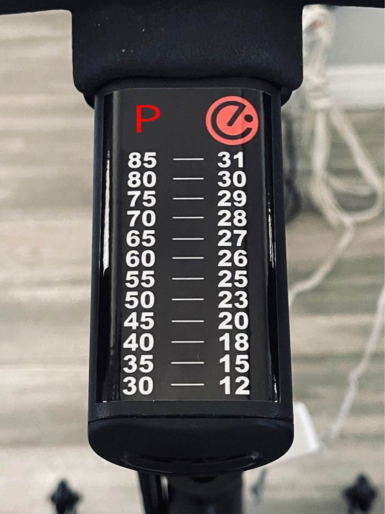 May include: A black and white resistance scale with a red "P" and a red circle with a white "C" inside. The scale shows numbers from 30 to 85 on the left and 12 to 31 on the right.