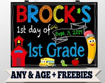以下が含まれることがあります： カラフルな文字で「BROCK'S 1st day of Sept. 3, 2017 1st Grade」と書かれた黒いチョークボードの看板。看板は赤い校舎、黄色のスクールバス、緑のミミズ、赤いリンゴで飾られています。下部には白いバナーに「ANY & AGE + FREEBIES」の文字があります。