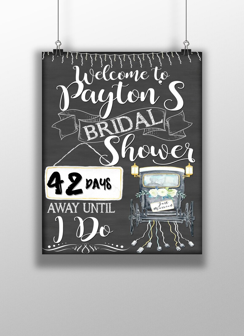 Puede incluir: Un letrero de pizarra con texto blanco que dice "Bienvenido al Bridal Shower de Payton 42 d&iacute;as antes del "Yo digo" ". El letrero tambi&eacute;n presenta una ilustraci&oacute;n en blanco y negro de un carruaje tirado por caballos con un letrero de "Just Married".