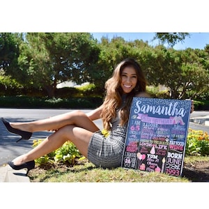 Puede incluir: Un letrero de pizarra con un dise&ntilde;o floral rosa y azul y el texto "Samantha 26th Birthday". El letrero enumera datos sobre Samantha, incluyendo su altura, sus comidas favoritas y su fecha de nacimiento. Una mujer sostiene el letrero y sonr&iacute;e a la c&aacute;mara.