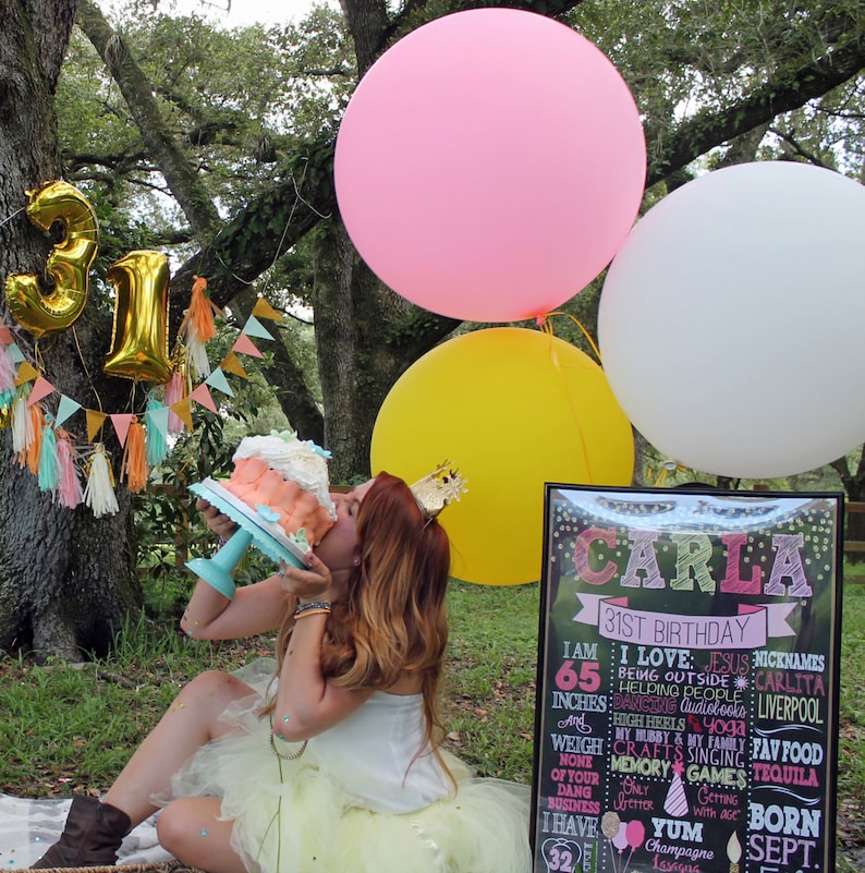 Puede incluir: Una mujer con una falda de tul amarilla y una blusa blanca est&aacute; celebrando su cumplea&ntilde;os n&uacute;mero 31. Est&aacute; sosteniendo un pastel rosa y blanco y est&aacute; rodeada de globos. El letrero detr&aacute;s de ella dice "Carla 31 cumplea&ntilde;os" y enumera algunas de sus cosas favoritas, incluyendo Jes&uacute;s, estar afuera y tequila.