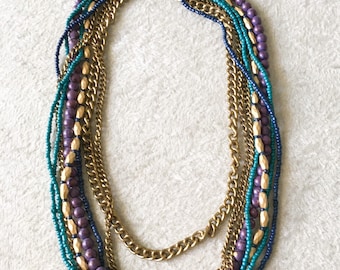 Collar de babero multibras de bronce, oro, púrpura y verde azulado.