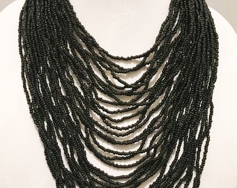 Collar largo de múltiples hilos de color negro.