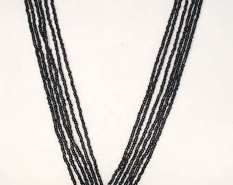 Collar largo de cuentas de semillas de múltiples hilos de color negro.