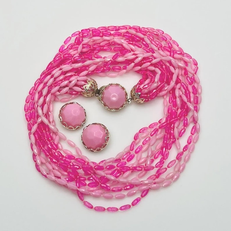 Mid-century pink beaded necklace with 12 strands and matching clip-on earrings, stamped Hong Kong, 1960s plastic jewelry set.
