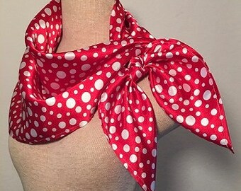 Peut inclure: Un foulard en satin rouge à pois blancs, noué autour du cou d'un mannequin.