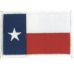 May include: A rectangular embroidered patch featuring the Texas state flag design. The patch has a vertical blue stripe on the left side with a single white five-pointed star, and horizontal white and red stripes on the right side with white borders.