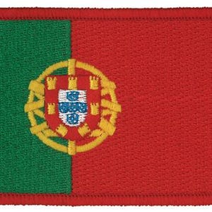 May include: A rectangular embroidered patch featuring the flag of Portugal. The design consists of a vertical green band on the left and a larger red band on the right, with the yellow armillary sphere and red shield emblem centered on the line.