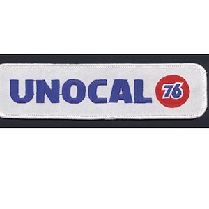 Pode incluir: Um emblema retangular bordado com fundo branco e borda costurada em branco. O texto UNOCAL está bordado em letras maiúsculas azuis, seguido por um círculo vermelho contendo o número 76 em azul com uma fonte sem serifa em negrito.