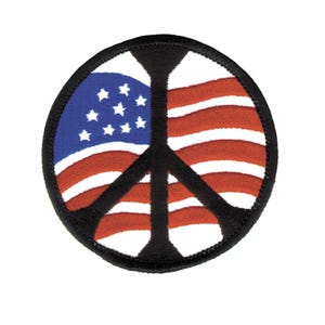 May include: A circular embroidered patch featuring a black peace sign symbol overlaid on a background of the American flag. The design includes a blue field with white stars on the left and horizontal red and white stripes, all bordered by black.