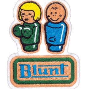 May include: Embroidered patch featuring two cartoon figures, one in green and the other in blue, with the word "Blunt" in blue text on a green and orange rectangle. The patch has a white border.