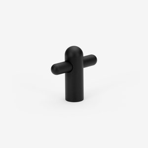 May include: Black cabinet knob with a rounded top and two short, horizontal arms.