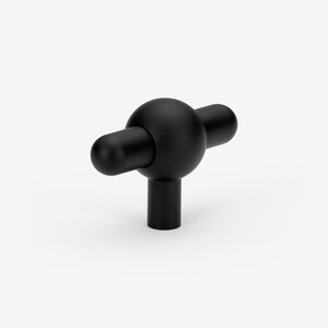 May include: Black T-shaped cabinet knob with a round ball in the center and two cylindrical handles extending from the sides.