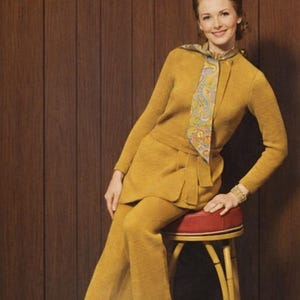 May include: Cover of "The Workbasket" magazine from February 1970. The cover features a woman in a mustard-yellow knit suit with a patterned scarf, seated on a red and gold stool. The magazine title and price are visible.