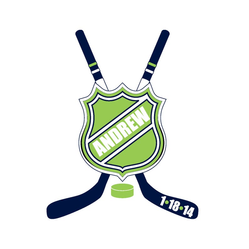 May include: A green hockey shield with the name "ANDREW" written in white on it. Two crossed hockey sticks with navy blue and white stripes are behind the shield. The sticks have the numbers "1-18-14" written on them.