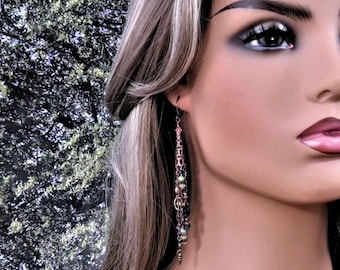 May include: Long, dangling earrings with a mix of beads, charms, and wire. The earrings are made of copper and feature a variety of colors, including green, pink, and black.