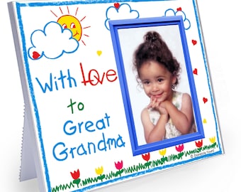 May include: A white picture frame with a blue border and a child's drawing of a sun, clouds, and flowers. The frame has a space for a photo and the words "With love to Great Grandma" written on it.