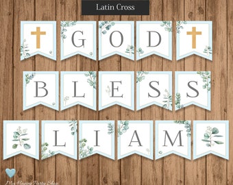 Pode incluir: Uma faixa azul e branca com as palavras "God Bless William" e uma cruz dourada em cada extremidade. A faixa é decorada com folhas de eucalipto.